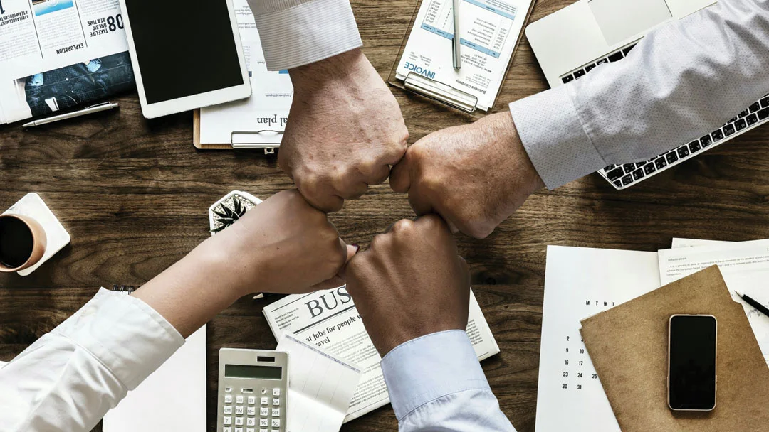 Photo of a business team fist bump in a meeting